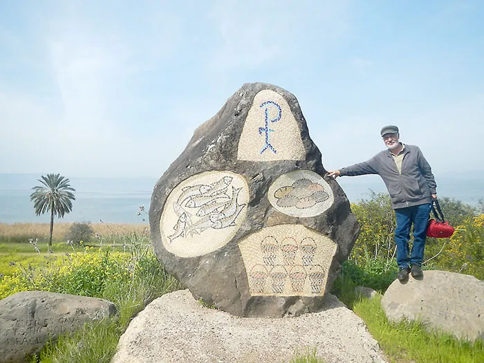 Trevor Harris standing beside a memorial near the Sea of Galilee